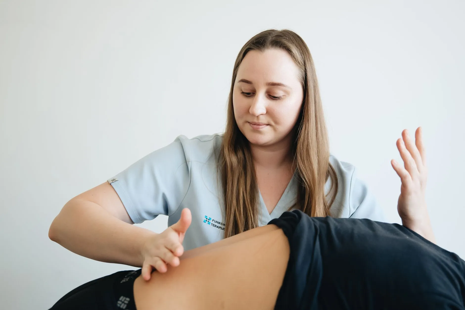 Fisioterapeuta realizando teste de mobilidade no quadril de um paciente