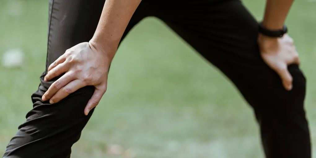 Atleta alongando a perna antes da atividade física