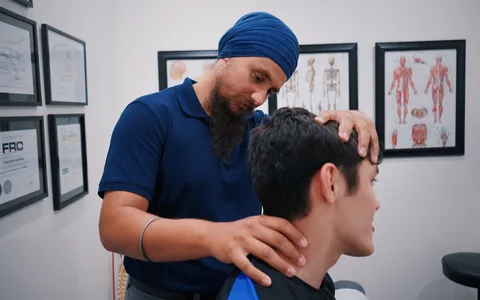 Fisioterapeuta avaliando a mobilidade cervical de um paciente