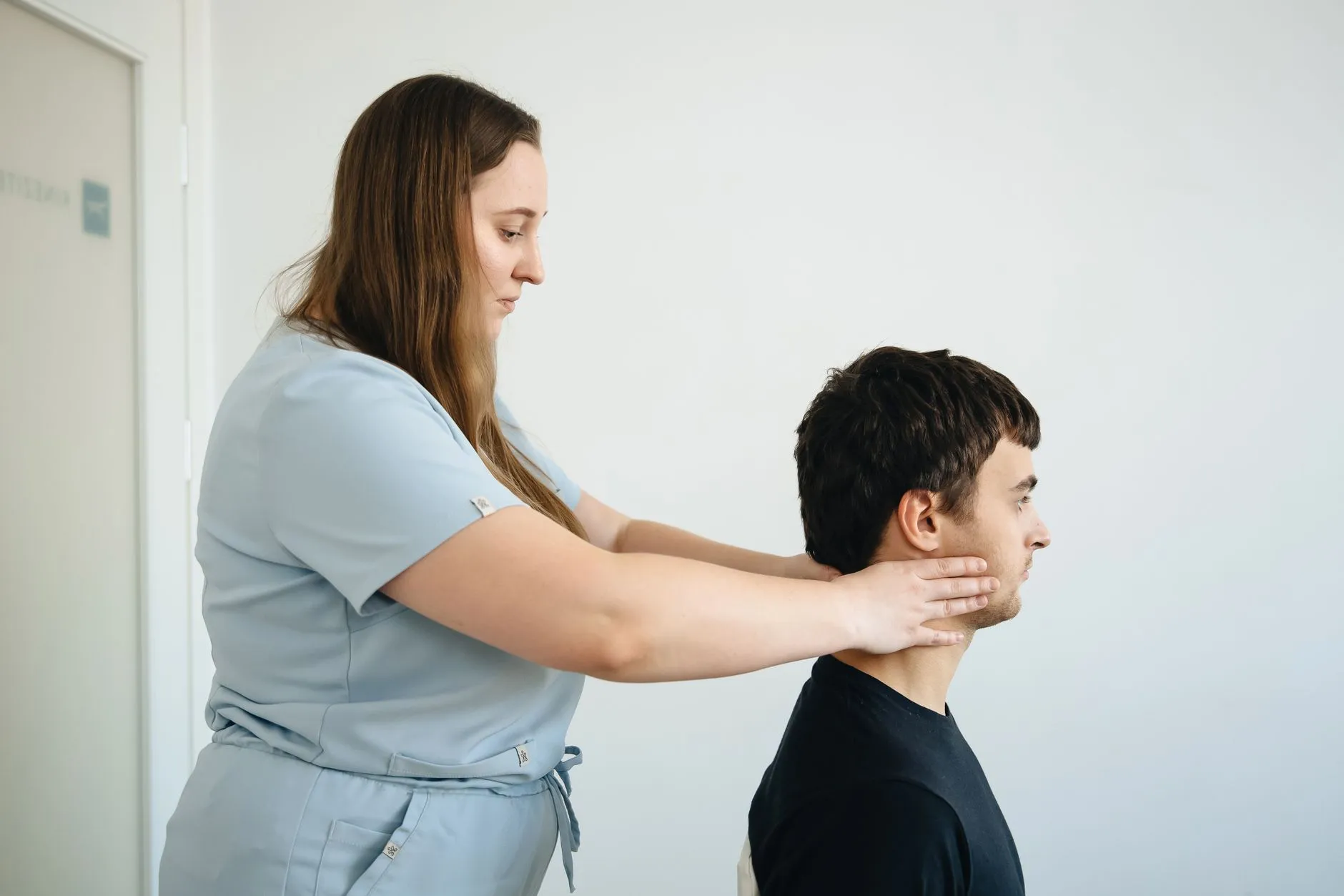 Fisioterapeuta realizando mobilização cervical em paciente
