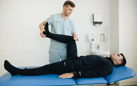 Fisioterapeuta avaliando a região lombar e a perna de um paciente