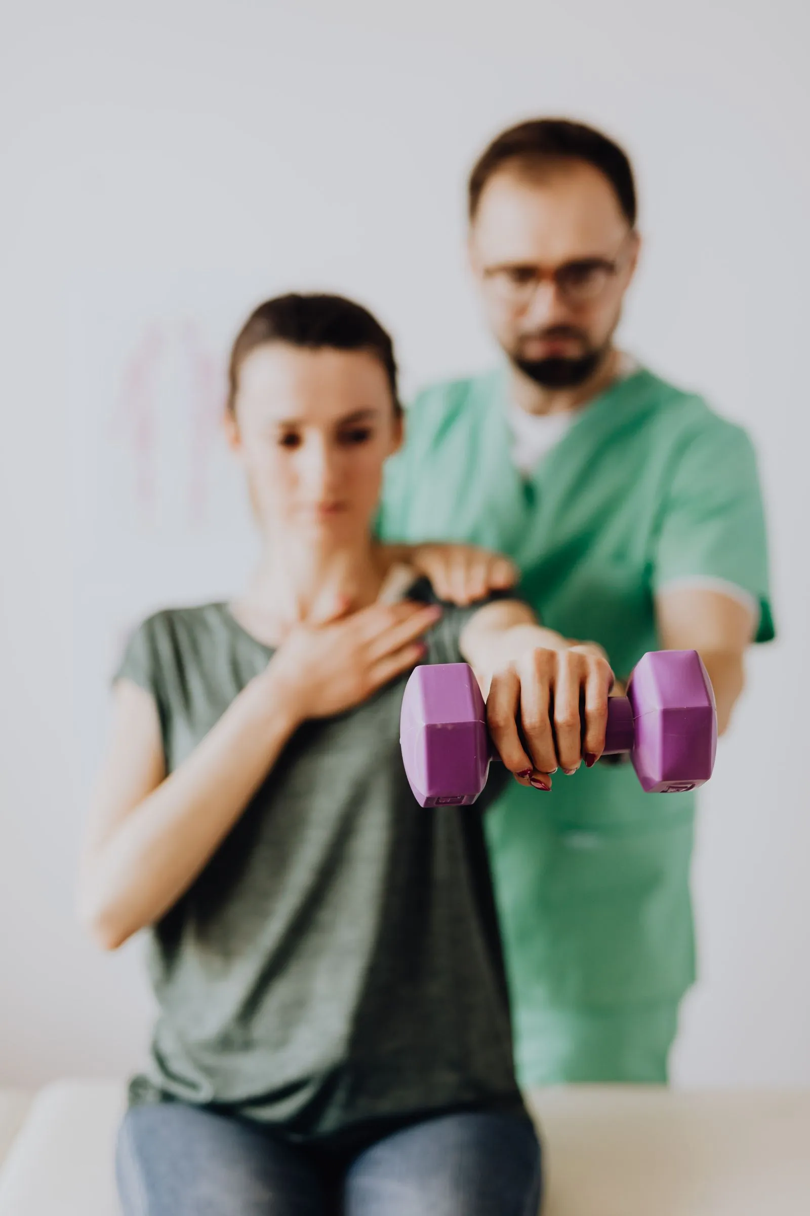 Fisioterapeuta orientando paciente durante exercício de fortalecimento com peso