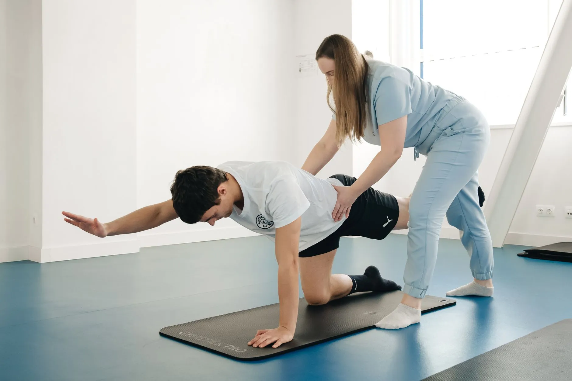 Fisioterapeuta orientando exercício postural com paciente