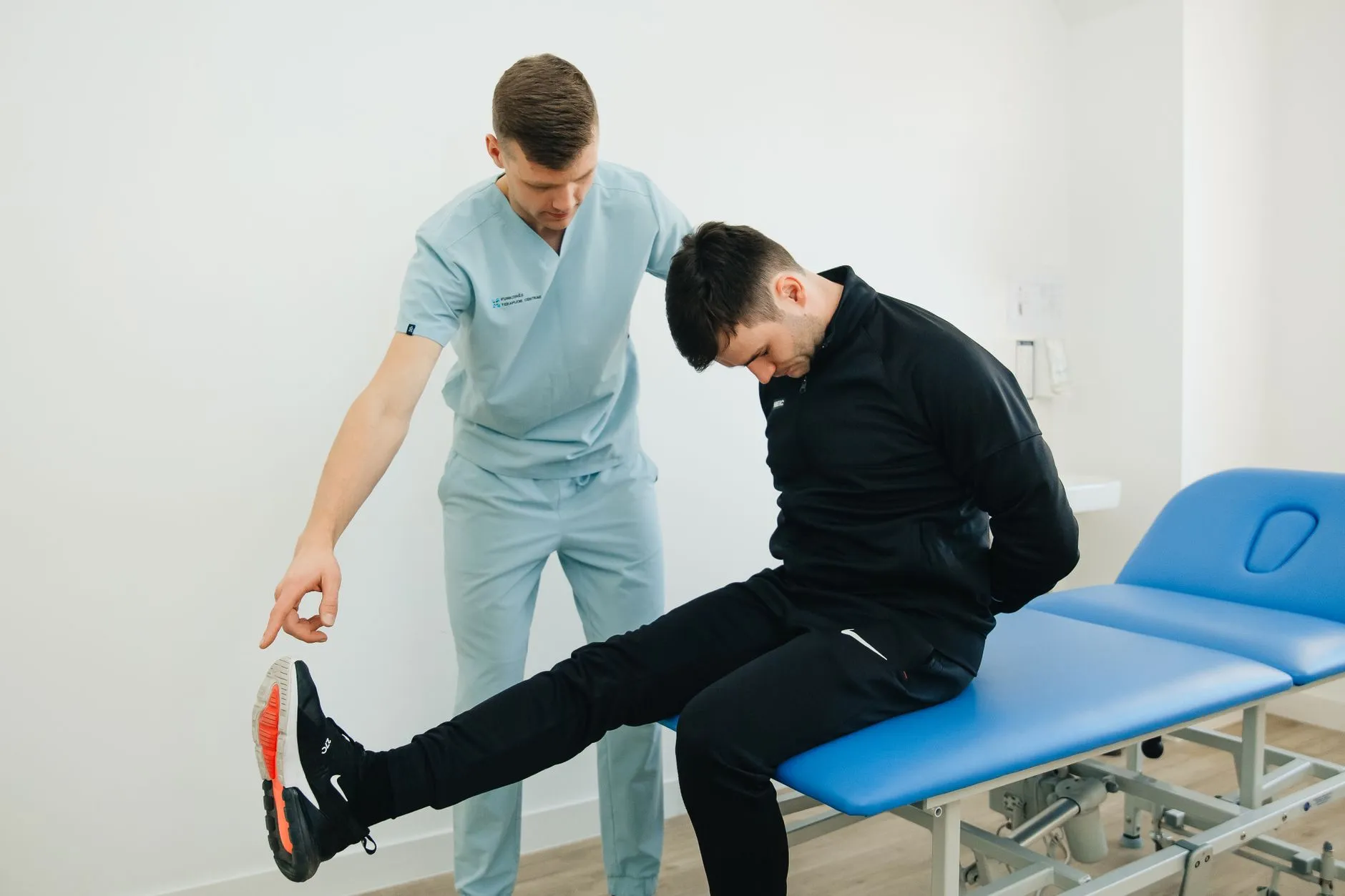 Fisioterapeuta orientando exercício de mobilidade de tornozelo em paciente