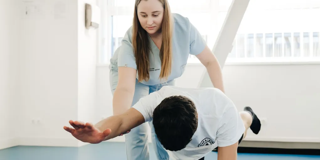 Fisioterapeuta acompanhando paciente em recuperação logo após uma cirurgia ortopédica