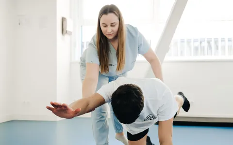 Fisioterapeuta acompanhando paciente em recuperação logo após uma cirurgia ortopédica