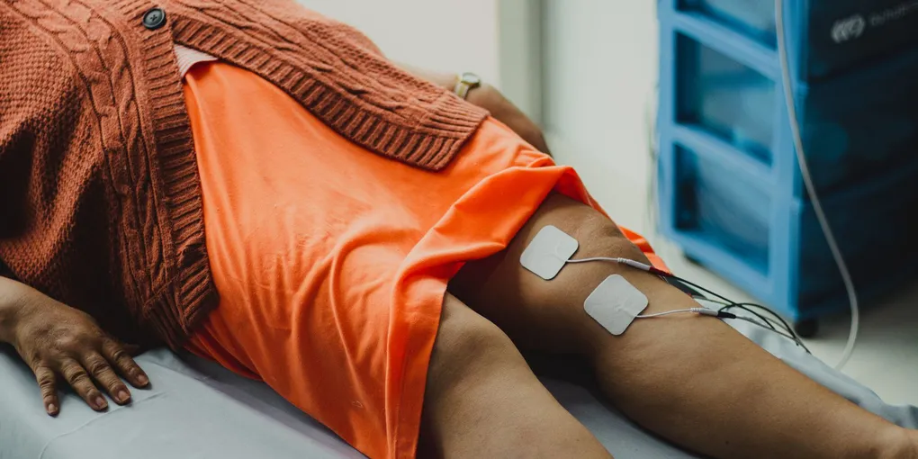 Fisioterapeuta avaliando a mobilidade do joelho de um paciente após cirurgia de prótese