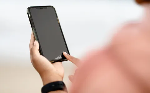 Pessoa olhando para o celular com o pescoço inclinado para baixo