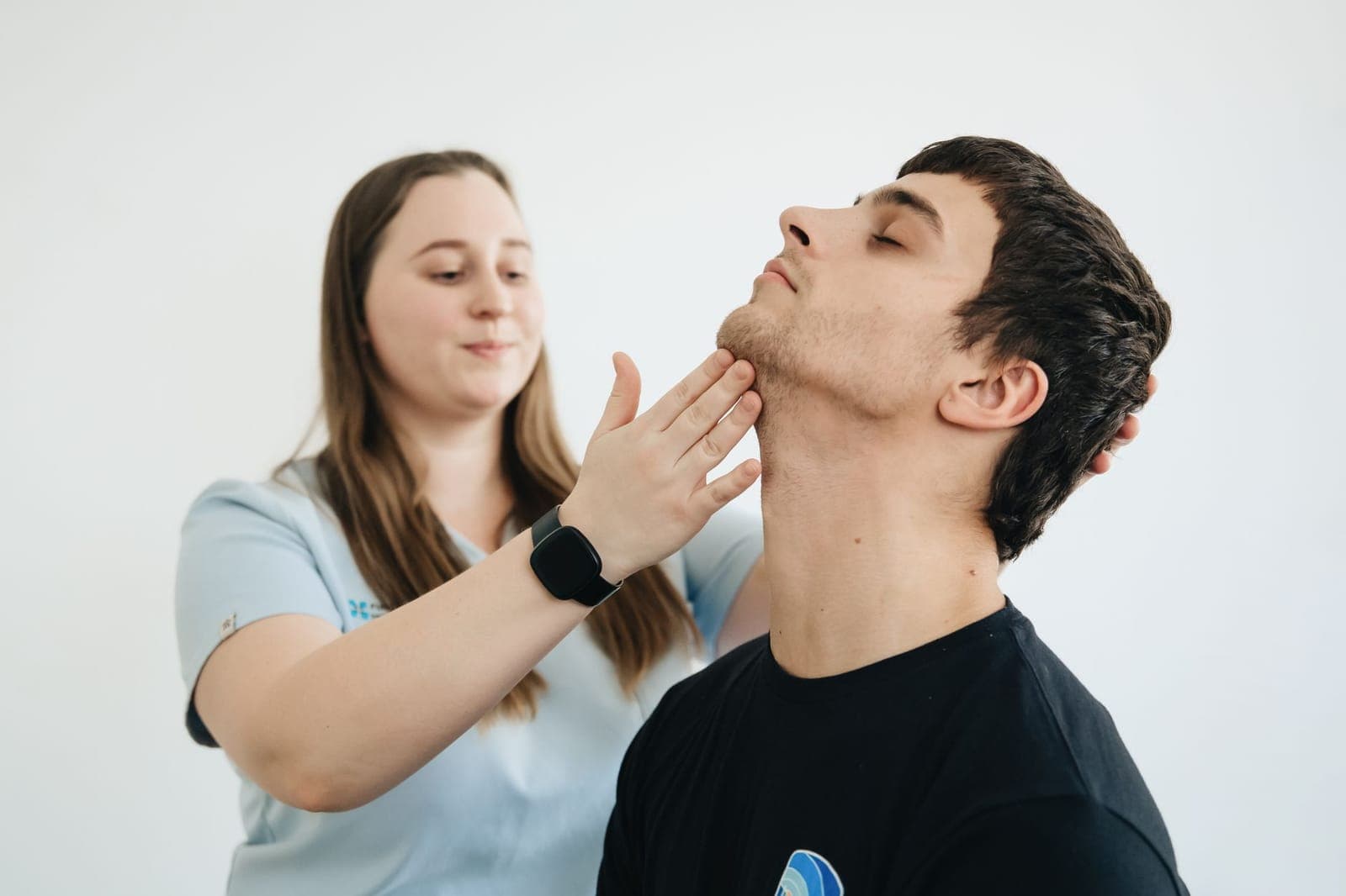 Fisioterapeuta examinando a coluna de um paciente durante avaliação