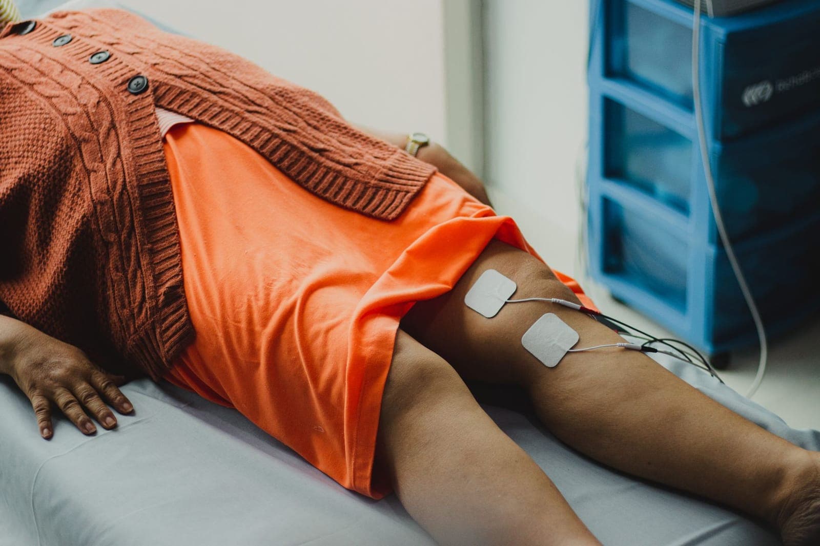 Fisioterapeuta avaliando a mobilidade do joelho de um paciente após cirurgia de prótese