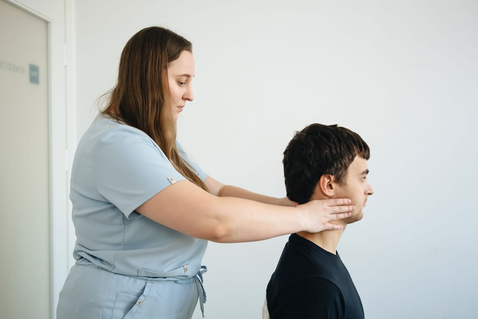 Fisioterapeuta realizando mobilização cervical em paciente